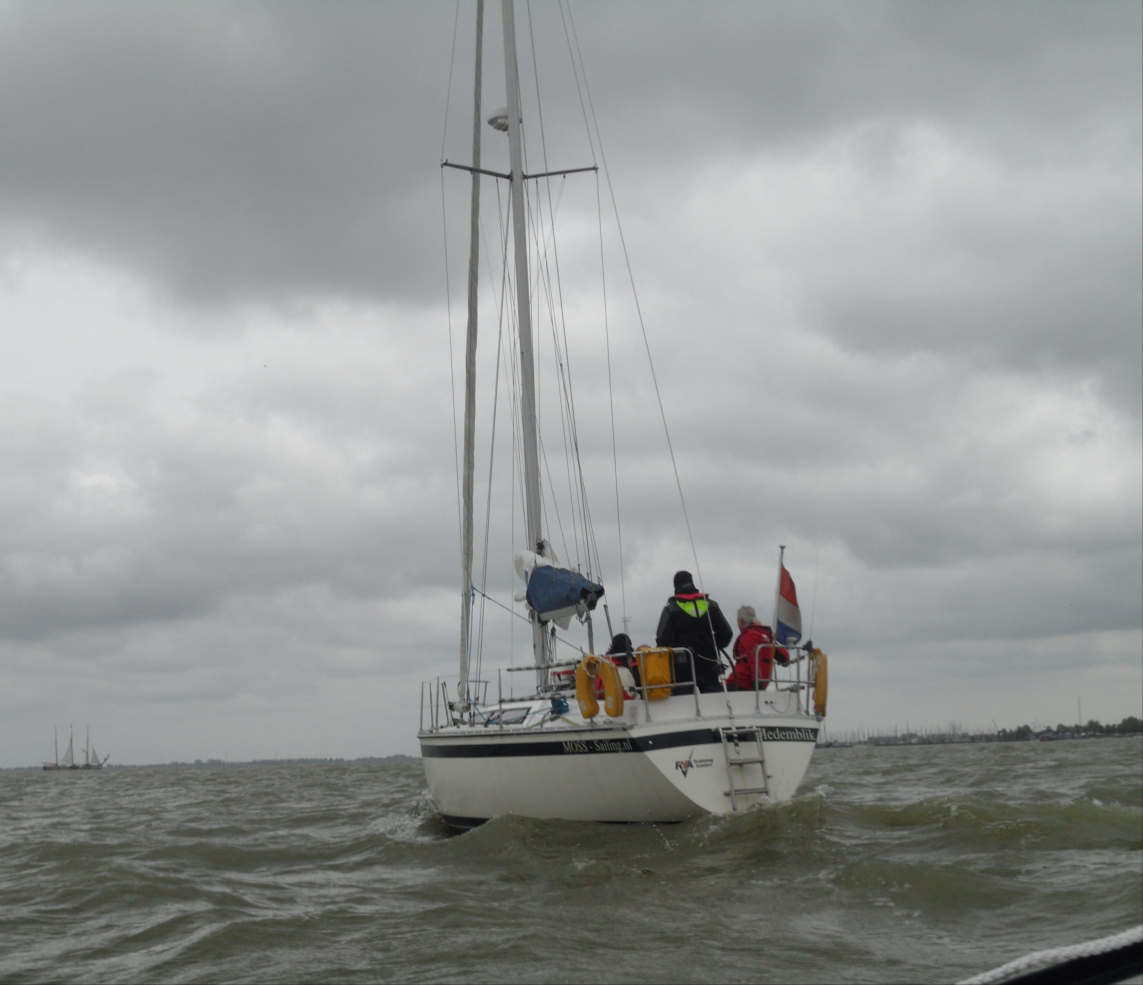 A MOSS Sailing training yacht under bare poles in the Markermeer under grey skies